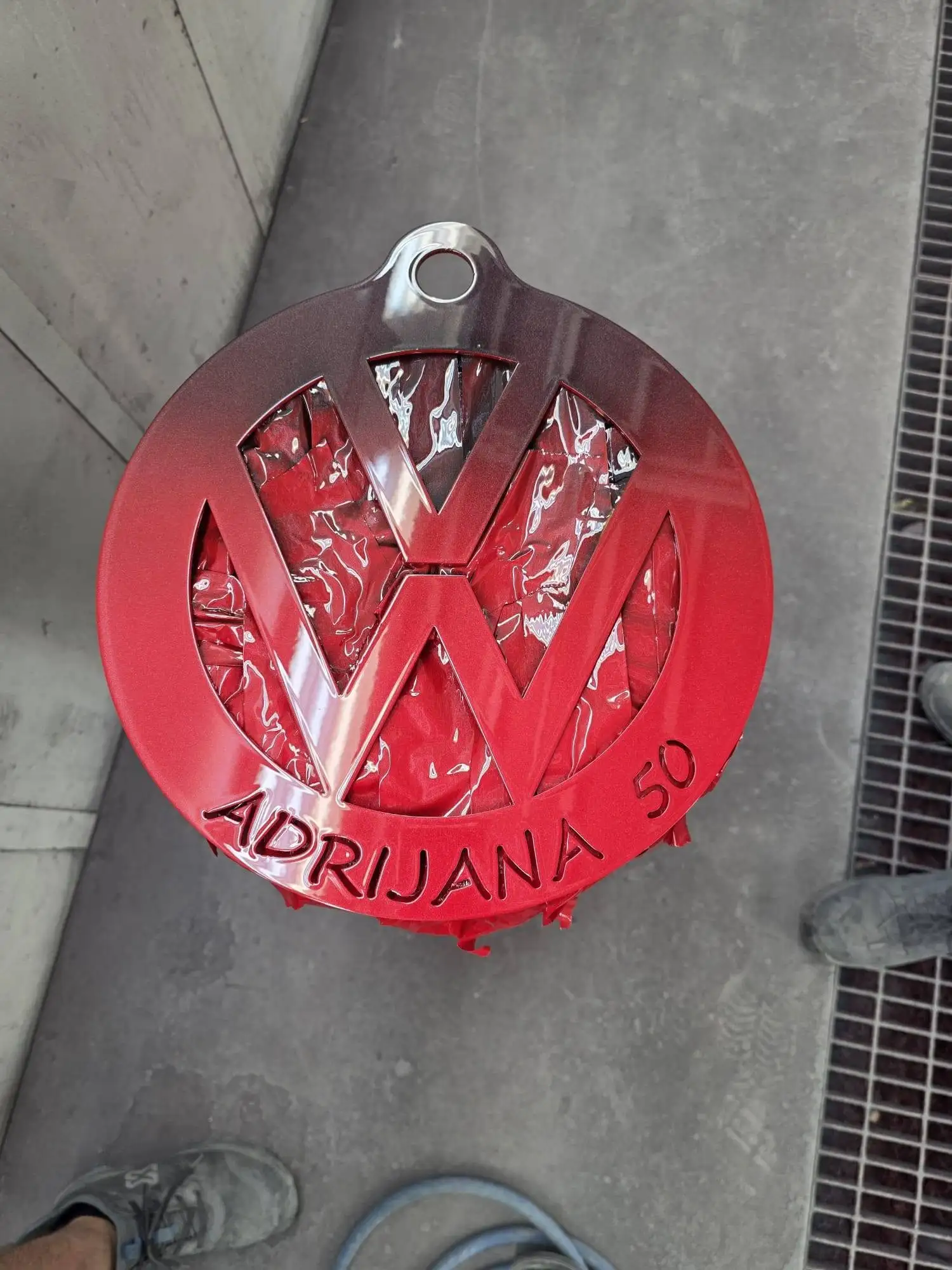 Sveže lakiran rdeč znak VW z napisom Adrijana 50